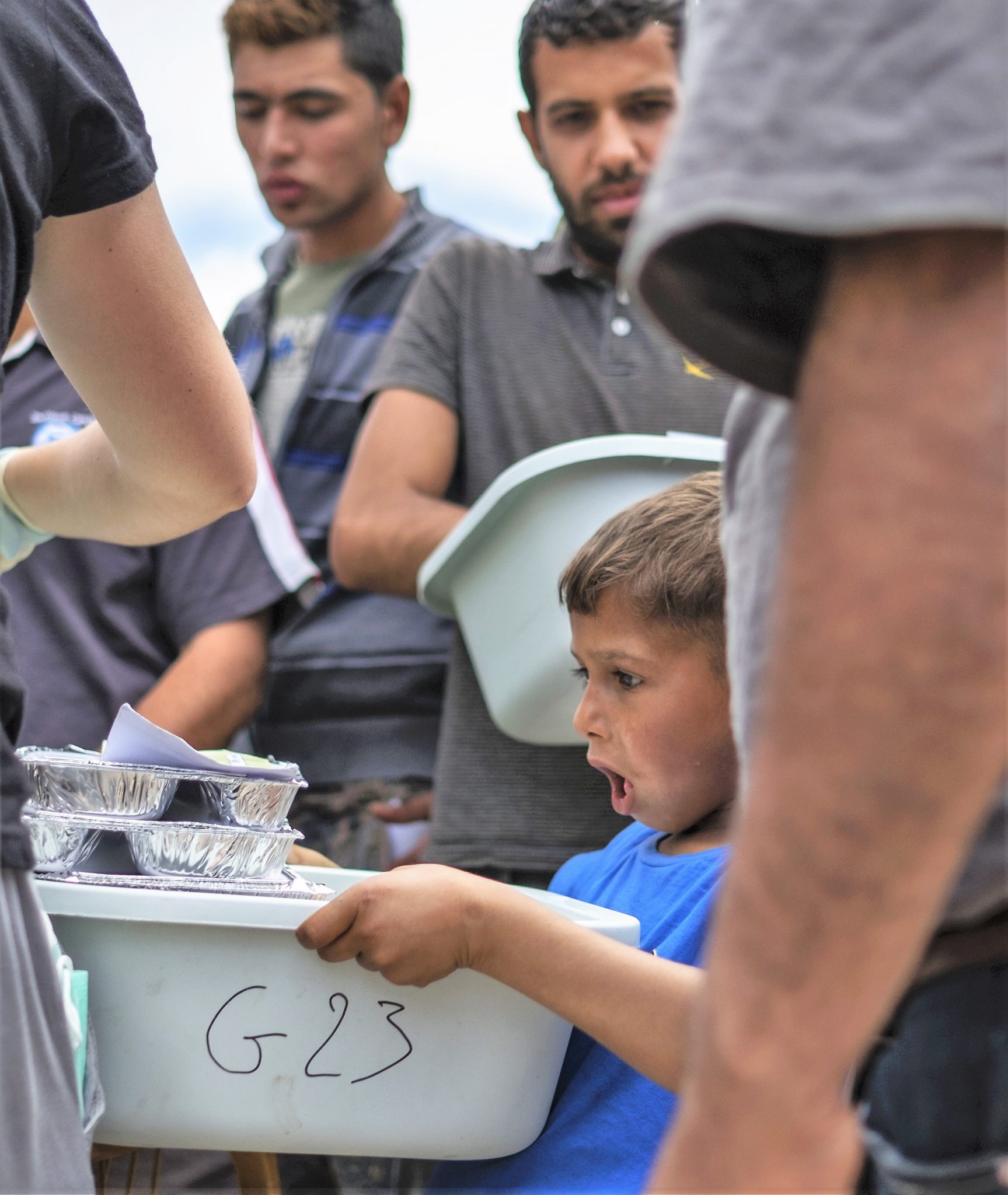 Un niño recibe su comida de Zaporeak Solidario. Chios. Grecia.