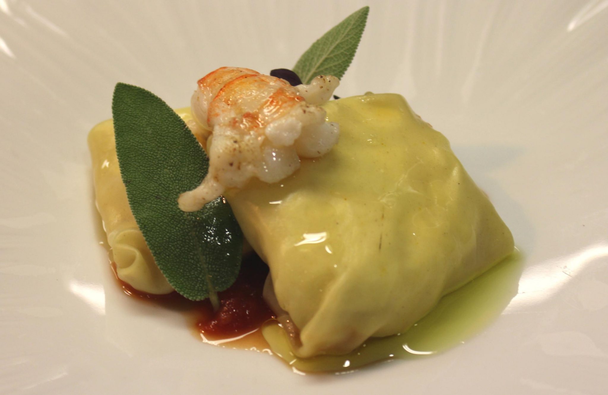 Ravioli de verduras braseadas, concentrado de tomate, cigala y aceite de salvia