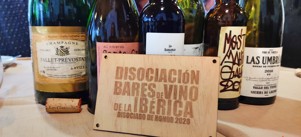 Algunos de los vinos bebidos durante la comida en el restaurante La Querencia en Gredos, y la placa de la Disociada de Honor, similar a las que los socios exhiben en sus establecimientos.