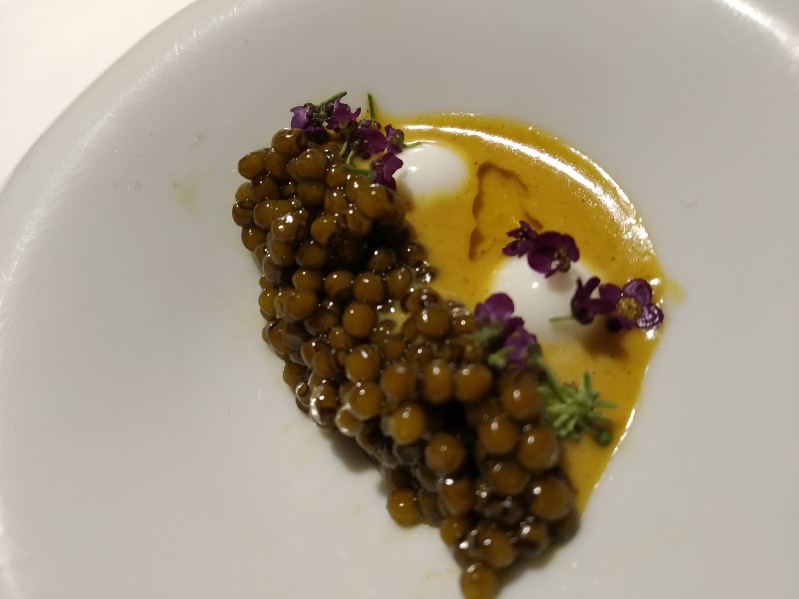 Caviar de esturión asado en un horno “tandoori” con curry “Vindaloo” y yogur griego. Plato de la secuencia indio del menú actual de Diverxo.