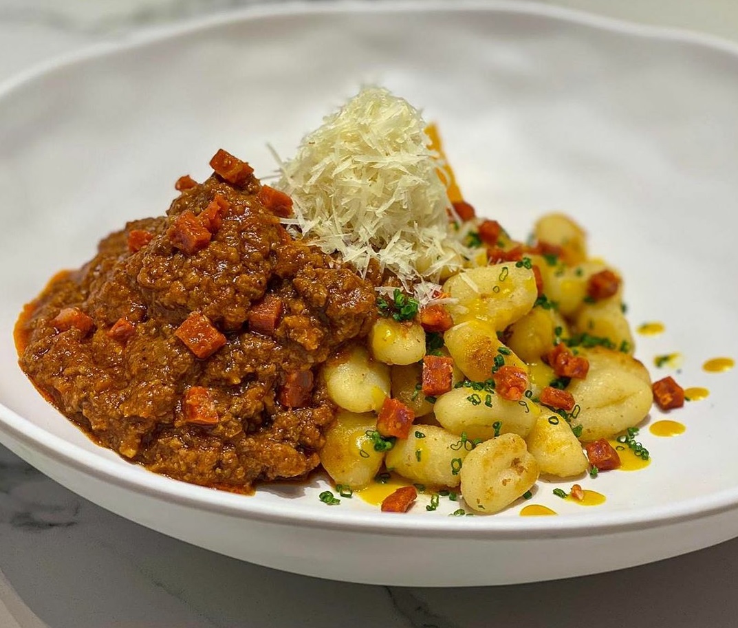 Gnoccis de patata con bolognesa de chorizo de León ahumado y crema de mandarina antigüa. GoXO.