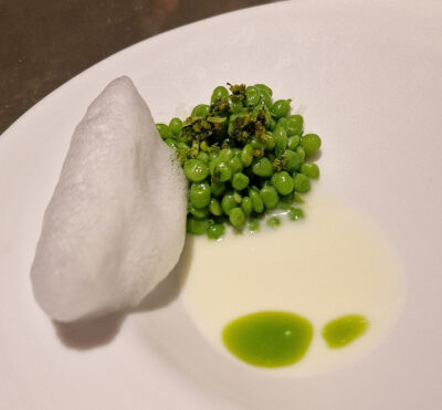 Guisantes lágrima con suero de mozzarella, aceite de menta y aire de agua de rosas.