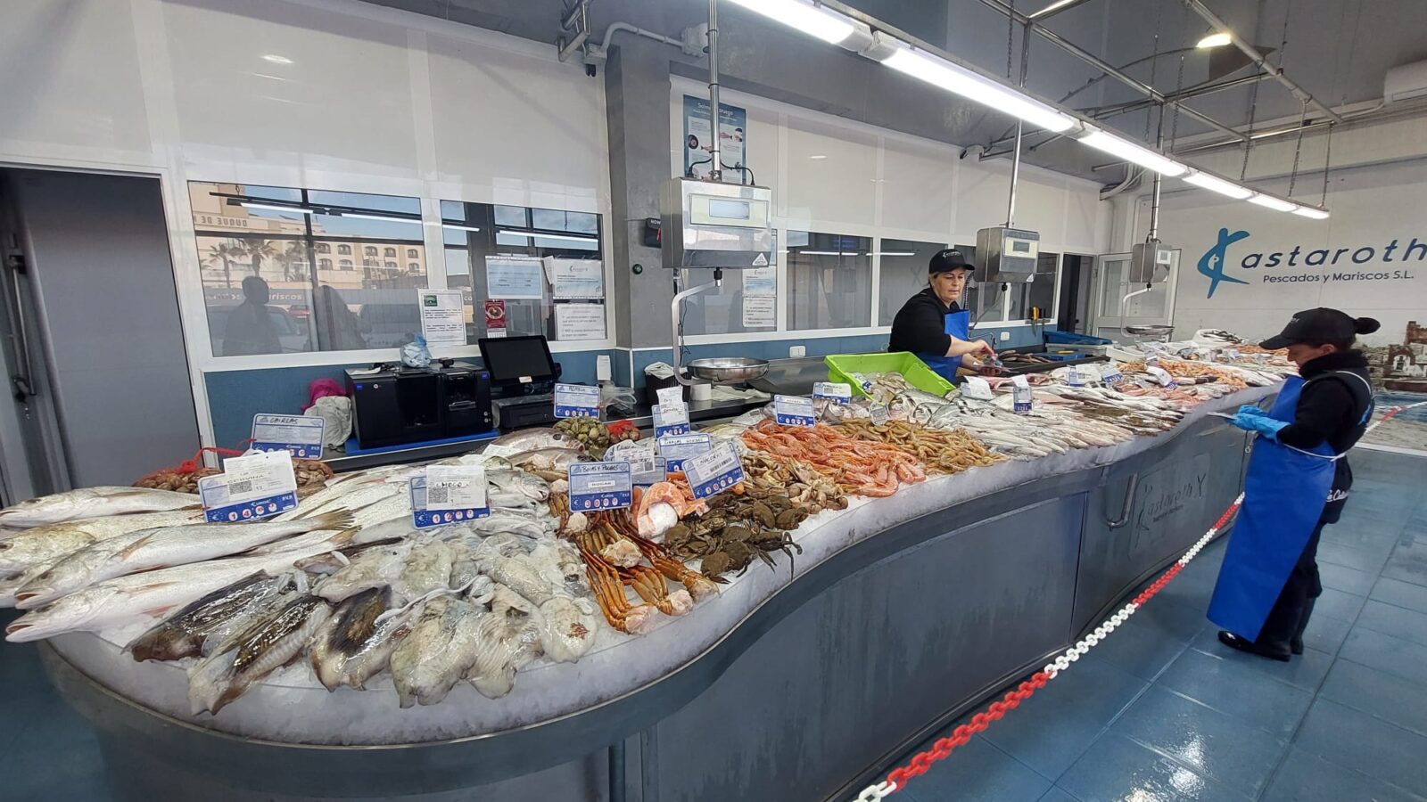 Antonia y Mercedes repasan los precios antes de abrir la pescadería