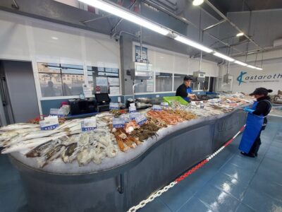 Antonia y Mercedes repasan los precios antes de abrir la pescadería