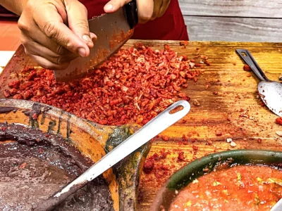 Un taquero pica carne sobre una tabla a un lado. Foto, Rodrigo Crespo.