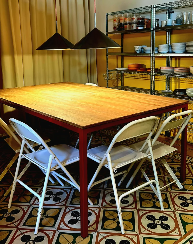 La imagen muestra el comedor de la casa, y cómo las mesas están pensadas para compartir veladas entre amigos.