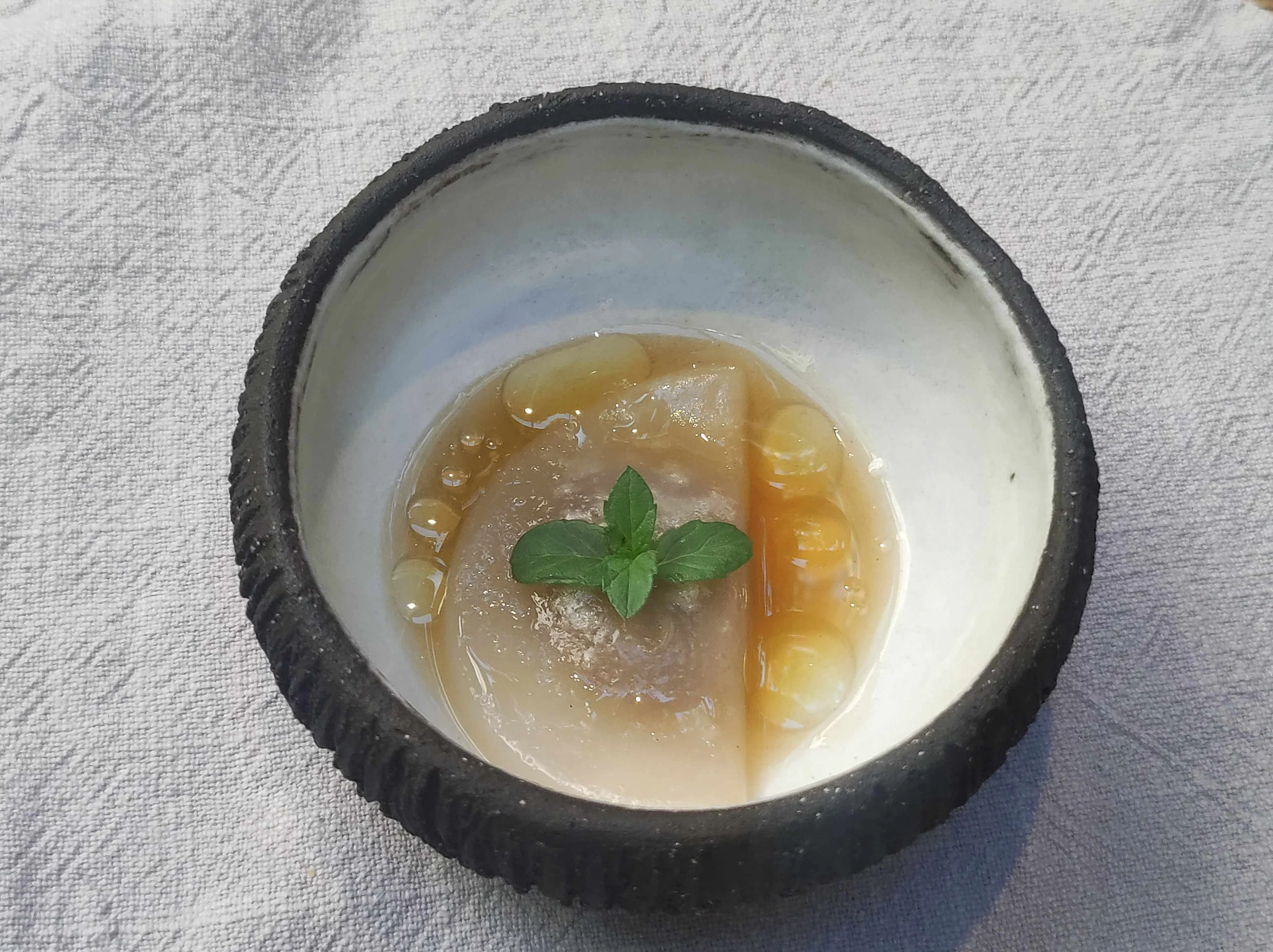 Raviol, asadurilla encebollada y aceite de pino