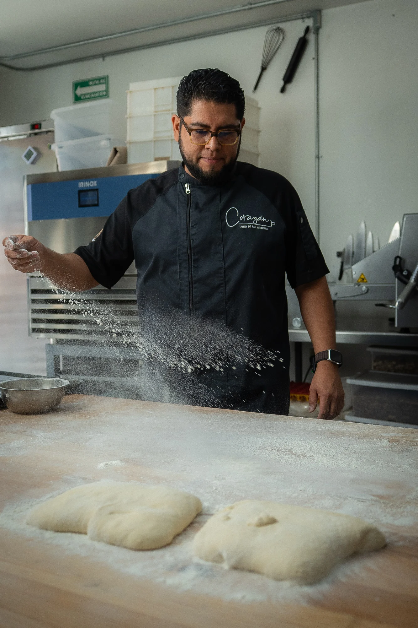 Isaac Hernández espolvorea de harina las bolas de masa para el levado del pan