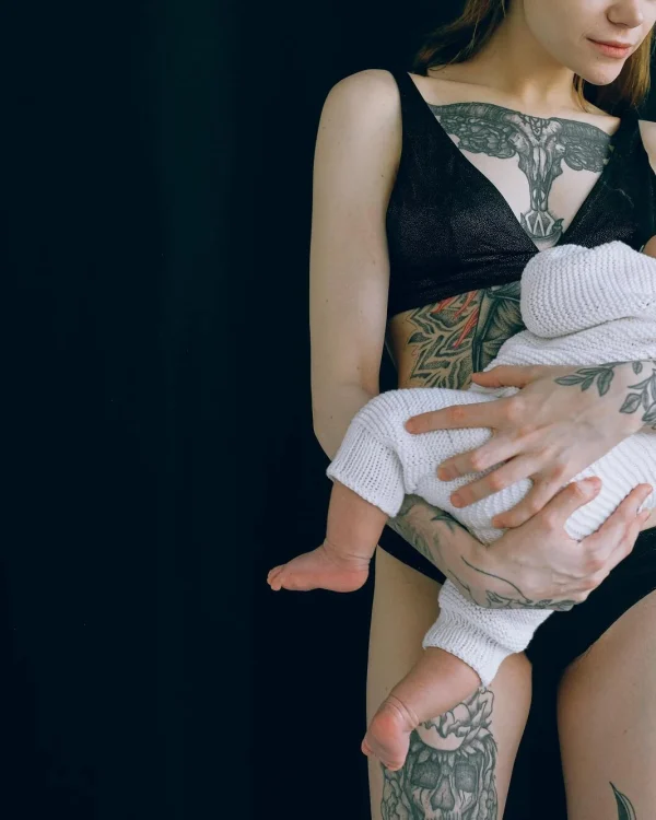 madre joven anónima abrazando a su bebé