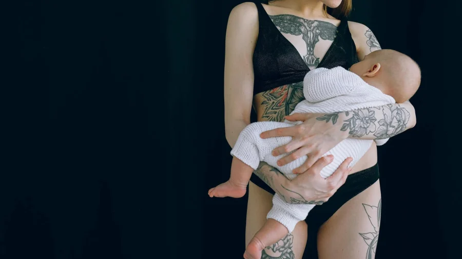 madre joven anónima abrazando a su bebé