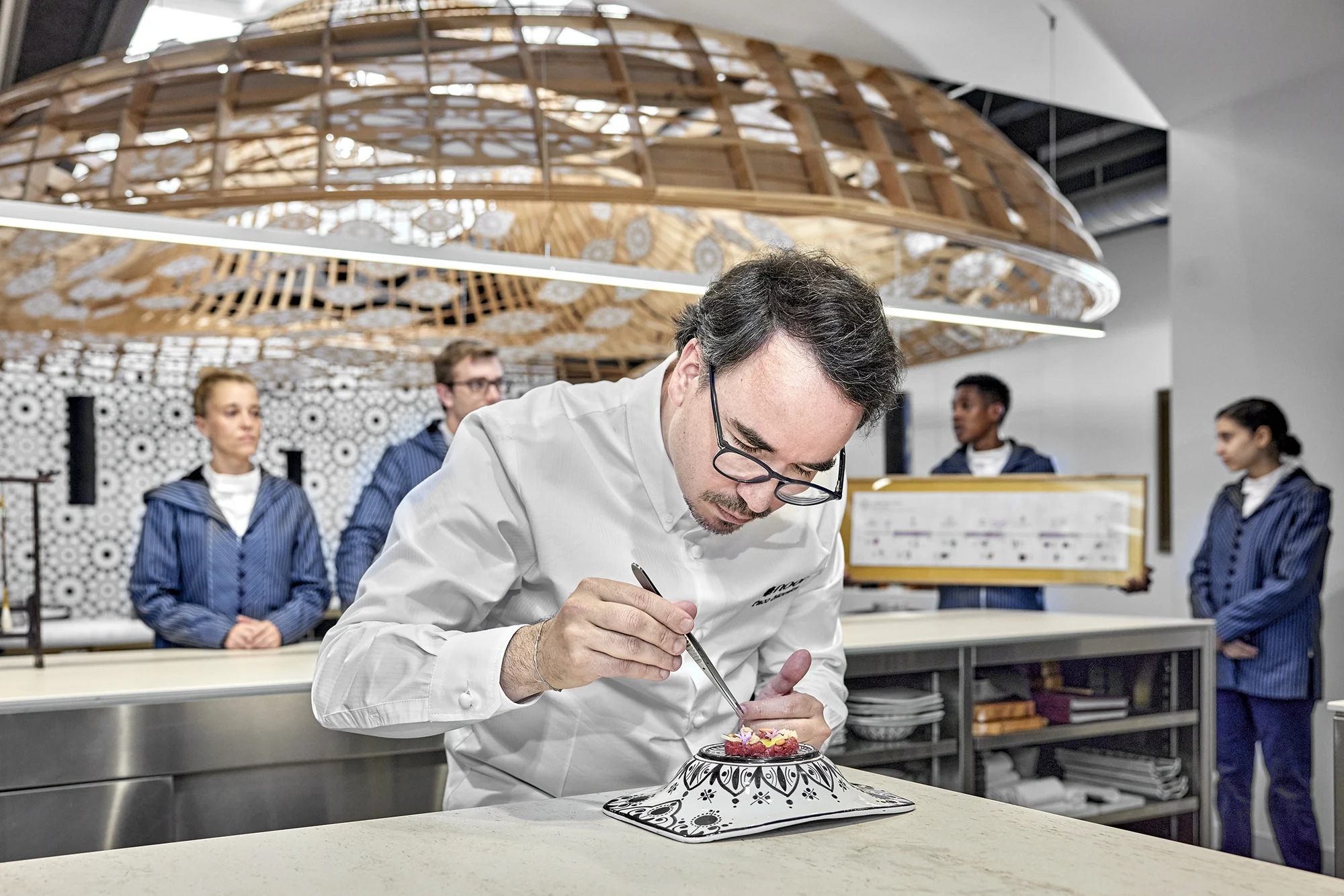 Paco Morales termina un plato durante un servicio en Noor.