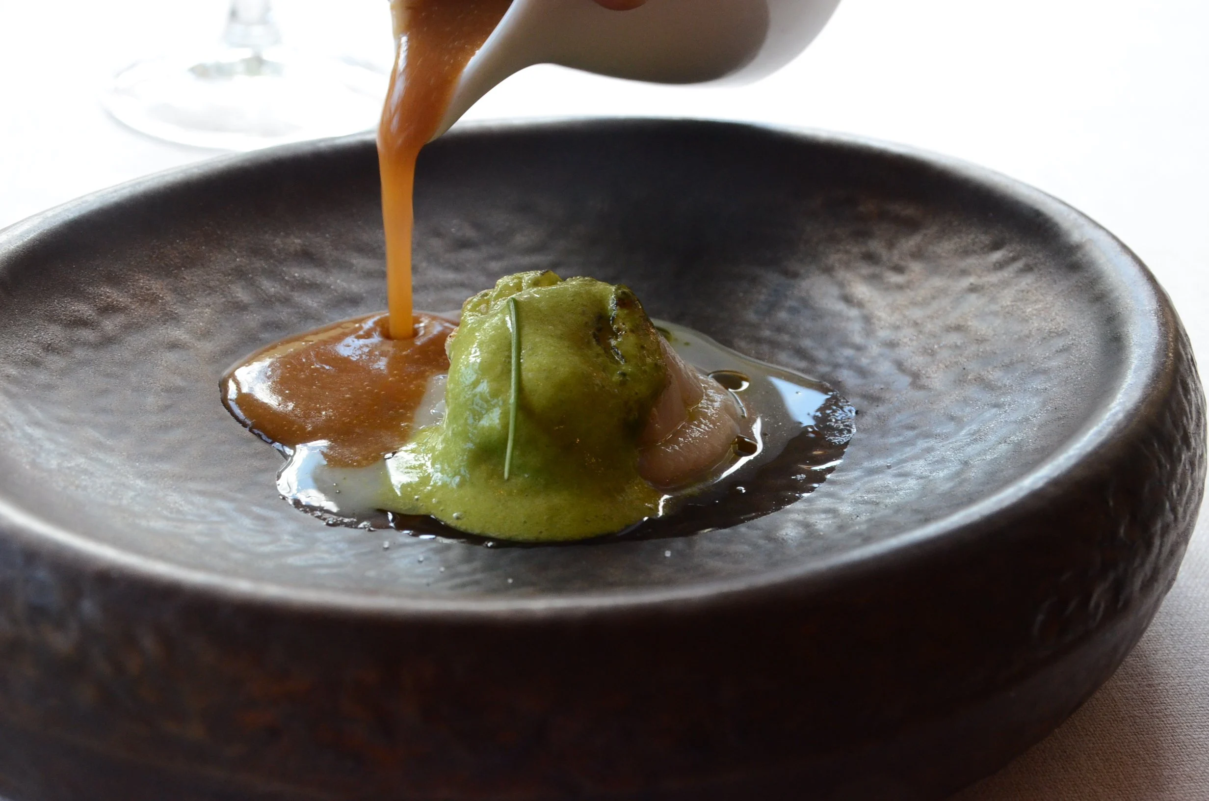 Ostra a la brasa con aire de alga kodium, aceite de puerro, cebollino y salsa americana